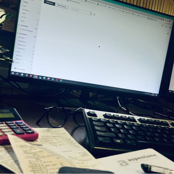 A computer showing Quickbooks Online and a calculator